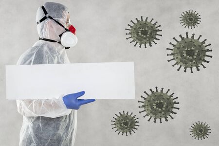 virologist in protective clothing holds advertising space in his handsの写真素材