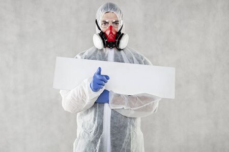 virologist in protective clothing holds advertising space in his handsの写真素材