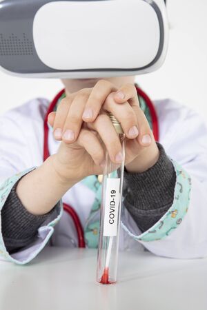 young doctor in virtual reality goggles holding tests for COVID-19の写真素材