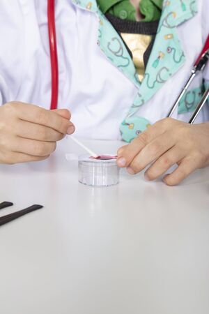 young doctor puts a blood sample on a glass slideの写真素材