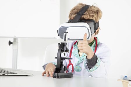 young doctor in virtual reality goggles is working on a 3D model of the virusの写真素材