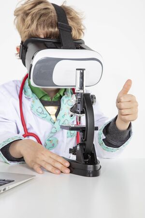 young doctor in virtual reality goggles is working on a 3D model of the virusの写真素材