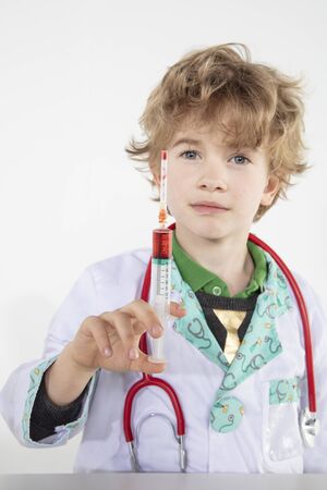 young doctor holds a syringe in his hand filled with vaccineの写真素材