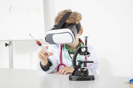 young doctor in virtual reality goggles is working on a 3D model of the vaccineの写真素材