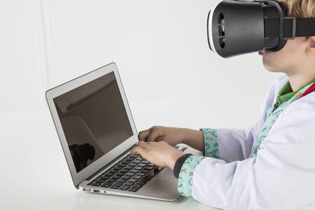 young doctor in virtual reality goggles is working on a 3D model of the virusの写真素材