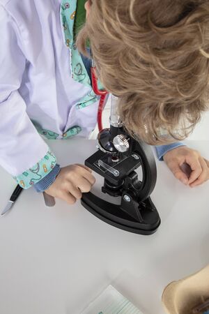 young doctor sitting over a microscope in his laboratoryの写真素材