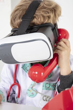 young doctor in virtual reality goggles talking on the phone, a symbol of globalizationの写真素材