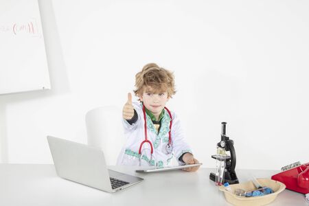 busy young doctor shows thumbs up, a symbol of good luckの写真素材
