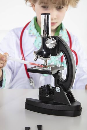  young doctor puts a blood sample on a glass slideの写真素材
