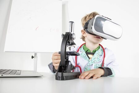 young doctor in virtual reality goggles is working on a 3D model of the virusの写真素材