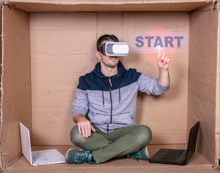 worker with VR glasses presses the virtual start buttonの写真素材