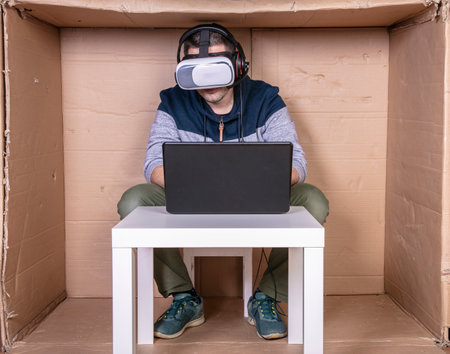 employee with virtual reality glasses working in his home cardboard officeの写真素材