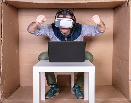 employee with virtual reality glasses working in his home cardboard officeの写真素材