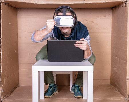 employee with virtual reality glasses working in his home cardboard officeの写真素材