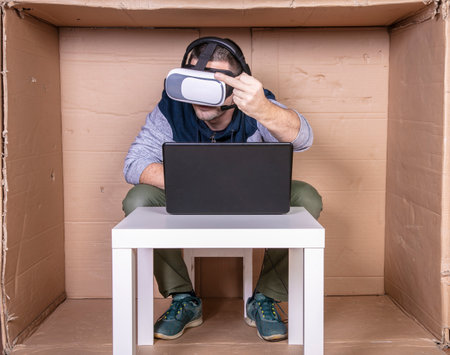 employee with virtual reality glasses working in his home cardboard officeの写真素材