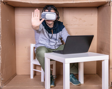 employee with virtual reality glasses working in his home cardboard officeの写真素材