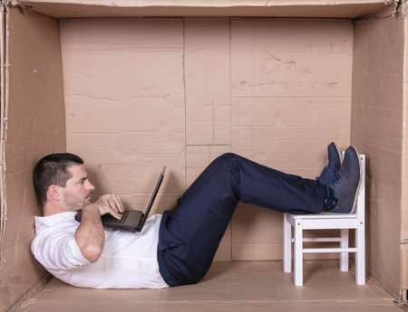 broken businessman in a cardboard office, stress and depression from overworkの写真素材