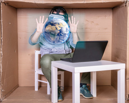 employee with virtual reality glasses working in his home cardboard officeの写真素材