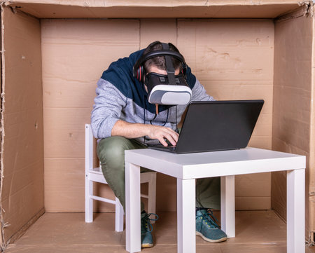 employee with virtual reality glasses working in his home cardboard officeの写真素材