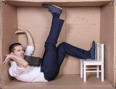 broken businessman in a cardboard office, stress and depression from overworkの写真素材