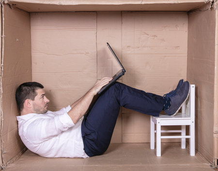 broken businessman in a cardboard office, stress and depression from overworkの写真素材