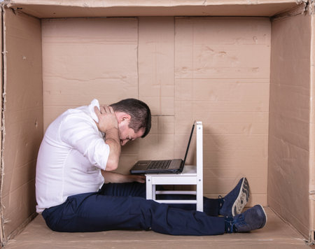 broken businessman in a cardboard office, stress and depression from overworkの写真素材