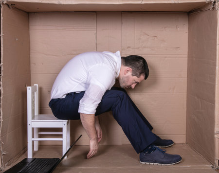 broken businessman in a cardboard office, stress and depression from overworkの写真素材