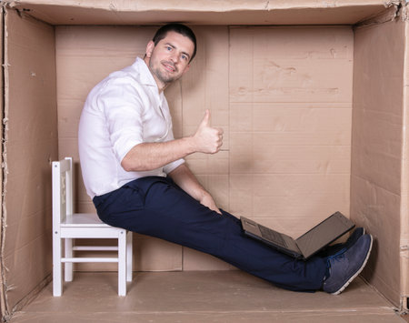 businessman seated in his cramped office satisfied with his workの写真素材