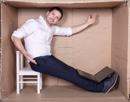 businessman seated in his cramped office satisfied with his workの写真素材