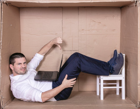 broken businessman in a cardboard office, stress and depression from overworkの写真素材