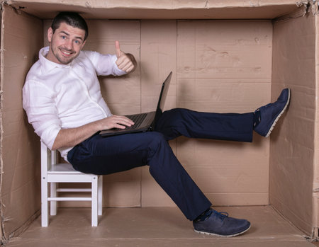businessman seated in his cramped office satisfied with his workの写真素材