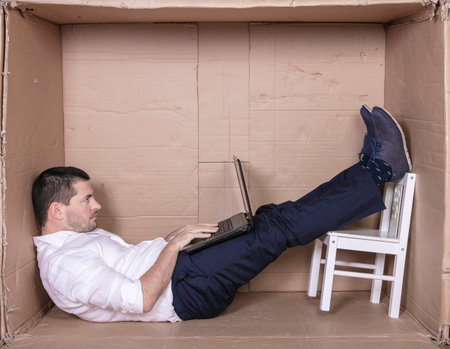 broken businessman in a cardboard office, stress and depression from overworkの写真素材