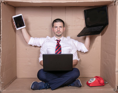 happy multitasking businessman ready for new challenges at work, multimedia tools in handsの写真素材