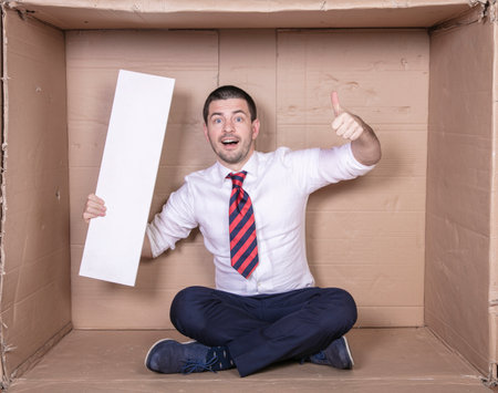 businessman shows thumbs up holding copy space in his other handの写真素材