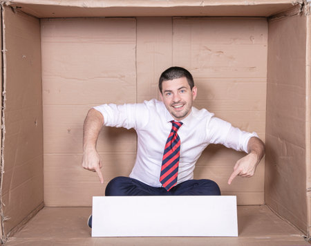 businessman points his fingers at copy space based on his legの写真素材