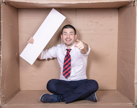 businessman pointing at you, holding copy space in his other handの写真素材