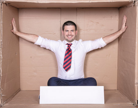 businessman expands his cardboard box, more space to workの写真素材