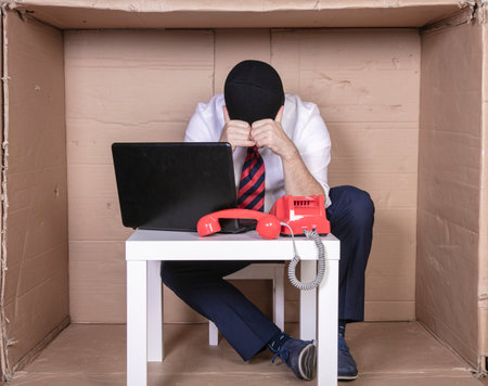 heartbroken businessman with balaclava on his face trying to counter internet crimeの写真素材