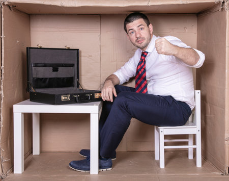 furious businessman threatens with his fist, empty briefcaseの写真素材