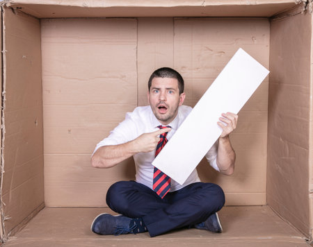 businessman with a funny puzzled expression points to copy spaceの写真素材