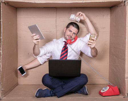 overworked businessman performs several tasks at once at work, concept of labor exploitationの写真素材