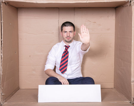 businessman shows stop gesture with his hand, copy space on white boardの写真素材