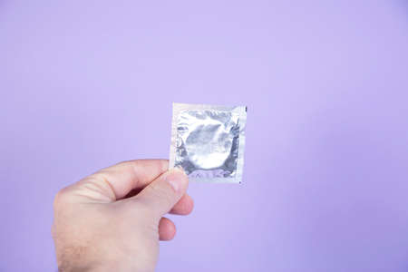 male hand holds condom, copy space