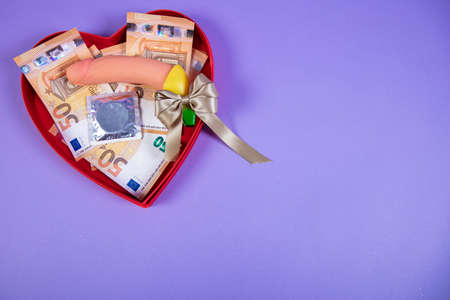 valentines day gift, erotic gadget, condom and money, copy space next to the gift
