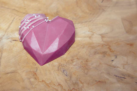isolated chocolate heart lies on a wooden boardの写真素材