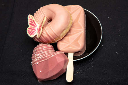 set of sweets lies on a black plate, isolated on a black backgroundの写真素材