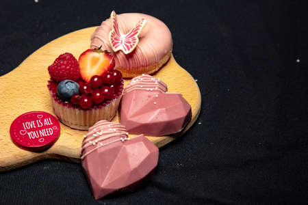 set of tasty sweets lies on a wooden board, black backgroundの写真素材