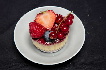 beautiful and tasty looking cheesecake on a black background, covert with fruit, view from aboveの写真素材
