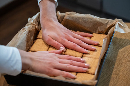 Close up of woman's hands taking cookies from box at home.の写真素材