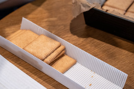 Biscuits in a paper box on a wooden table in a restaurantの写真素材